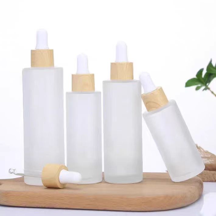 30ml 50ml 100ml Custom Pearl White Round Flat Shoulder Dropper Bottles Serum Glass Bottle With Wood Grain Cap for Essential Oil